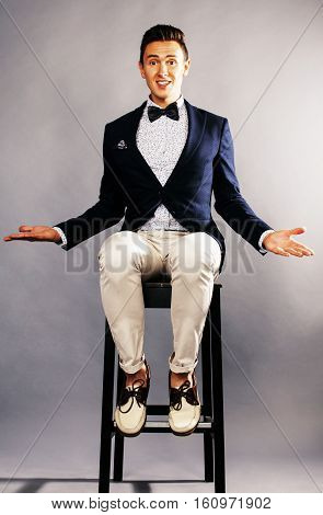 young handsoman businessman fooling aroung with chair, woundering gesturing, lifestyle people concept close up