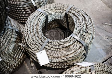 Coils of steel cable. Several steel wire rope rings stacked on the floor.