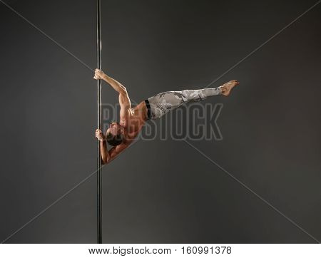 Young sexy athlete making sport exercises on pilon studio shot