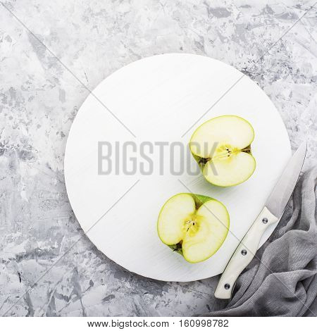 fashionable colors, the greenery apples on a gray marble table on a white cutting board. Top view