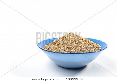Blue bowl of barley grits isolated on white. On right side