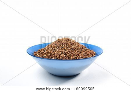 Buckwheat grains in Blue bowl from above isolated on white background. On center side