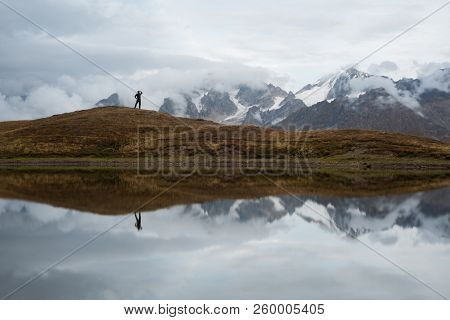 Koruldi lake with a mirror reflection of clouds. View of the Caucasus Mountains. Tourist enjoys the picturesque landscape. Samegrelo-zemo svaneti, Georgia