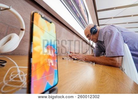 Strasbourg, France - Sep 21, 2018: Side View Of Funny Curious Senior Man Testing Apple Beats By Dr D
