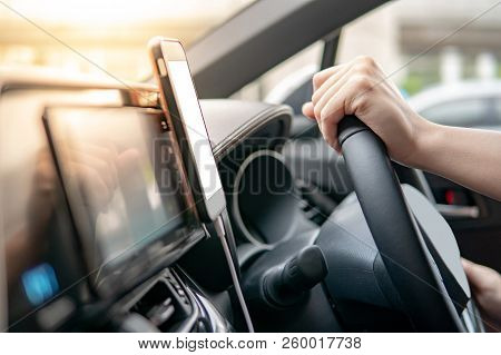 Male Driver Hand Holding On Steering Wheel Using Smartphone For Gps Navigation. Mobile Phone Mountin