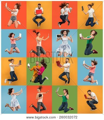Jump Of Young Women And Man Over Colorful Studio Background Using Laptop Or Tablet Gadget While Jump