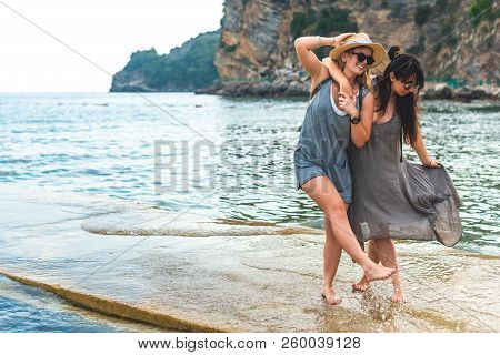 Attractive Women Hugging And Having Fun On Pier At Ricardova Glava Beach, Budva, Montenegro