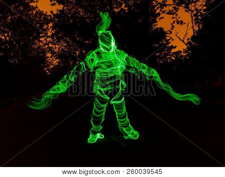 Long Exposure Photograph With Lightpainting Technique Representing An Illuminated Man.