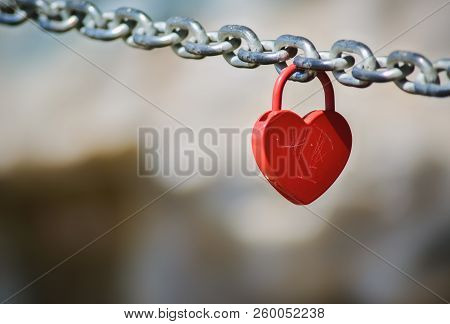 Red Padlock In Shape Of Heart Hanging On A Chain