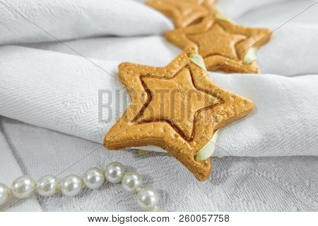 Decorative Golden Star Handmade From Dough On A White Fabric Surface. Limited Depth Of Field.