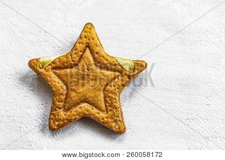 Decorative Golden Star Handmade From Dough On A Bright White Fabric Surface. View Of The Top.