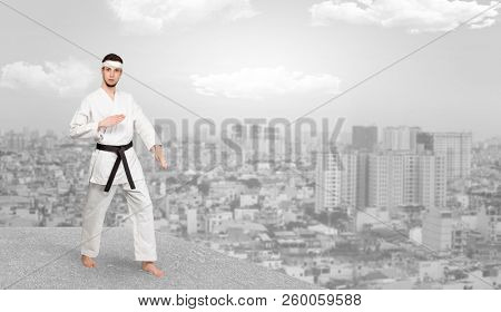 Young karate trainer doing karate tricks on the top of a metropolitan city