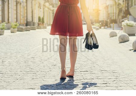 Close Up Cropped Rear Back Behind View Photo Of  Woman In Red Dress Holding High Heel Shoes In Hands