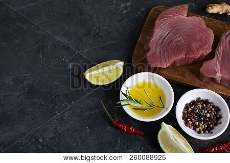 Raw Tuna Steak Wooden Cutboard Lime Slice Olive Oil Rosemary Fresh Ginger Root Chili Pepper Mix Blac