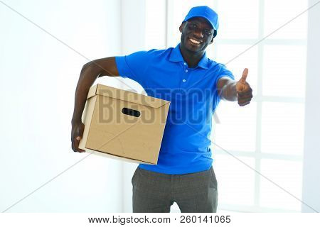 Portrait Of An Handsome Happy Deliverer With Box