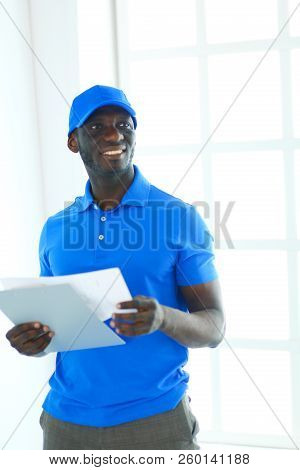 Portrait Of An Handsome Happy Deliverer With Folder