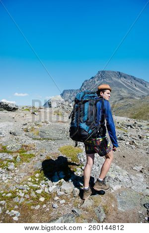 Traveler With Big Backpack Hiking On Besseggen Ridge In Jotunheimen National Park, Norway