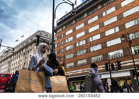 London, Uk - June 9, 2015: An Elderly Arab Woman In A Burqa Walks With Purchases From The Primark St