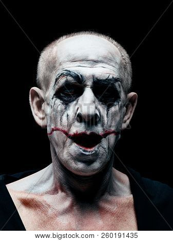 Bloody Halloween Theme: The Crazy Smiling Maniak Face On Dark Studio Background