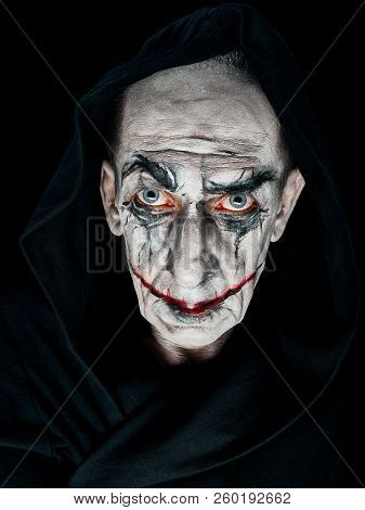 Bloody Halloween Theme: The Crazy Smiling Maniak Face On Dark Studio Background