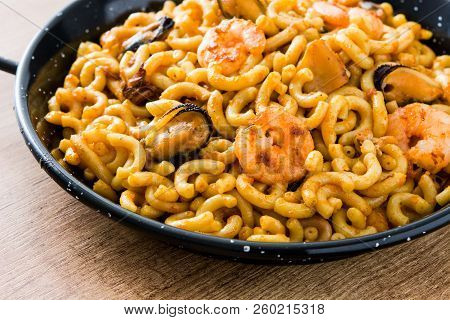 Traditional Spanish Fideua. Noodle Paella On Wooden Table. Close Up