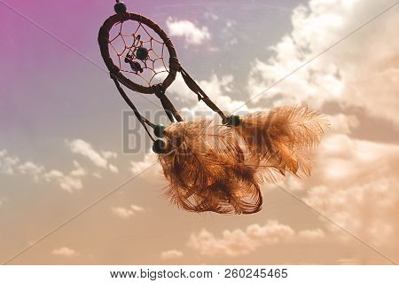 Dream Catcher Over A Colourful And Cloudy Sky. The Clouds Are Painted Of Different Colours As Purple
