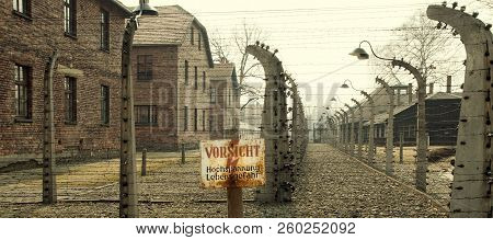 Auschwitz, Poland - March 30 2012 Melancholic View Through A Wired Electric Fence Of A Concentration