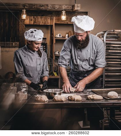 Chef Teaching His Assistant To Bake The Bread In A Bakery.