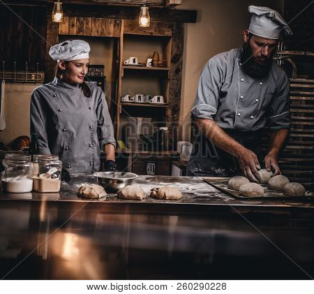 Chef Teaching His Assistant To Bake The Bread In A Bakery.