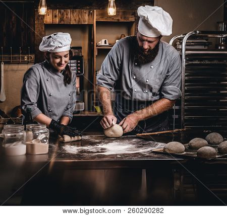 Chef Teaching His Assistant To Bake The Bread In A Bakery.