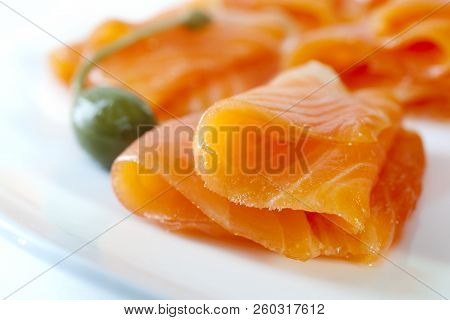 Cold Smoked Salmon On A White Plate With A Caperberry