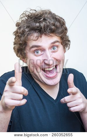 Portrait Of Young Caucasian Ethnicity Funny Curly Man Pointing Fingers On Camera On White Background