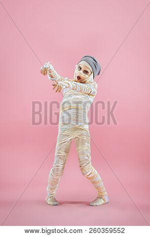 Studio Image Of A Young Teen Girl Bandaged, On Pink Background. Bloody Halloween Theme: The Crazy Ma