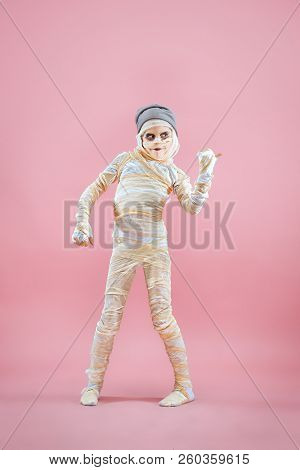 Studio Image Of A Young Teen Girl Bandaged, On Pink Background. Bloody Halloween Theme: The Crazy Ma