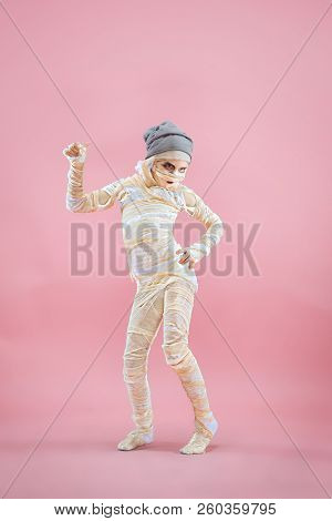 Studio Image Of A Young Teen Girl Bandaged, On Pink Background. Bloody Halloween Theme: The Crazy Ma