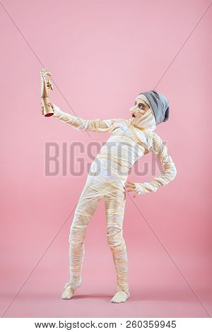 Studio Image Of A Young Teen Girl Bandaged, On Pink Background. Bloody Halloween Theme: The Crazy Ma