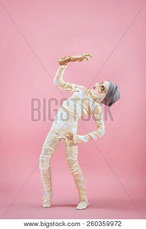 Studio Image Of A Young Teen Girl Bandaged, On Pink Background. Bloody Halloween Theme: The Crazy Ma