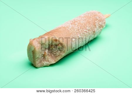 Green Bean Popsicle On A Light Green Background With A Bite