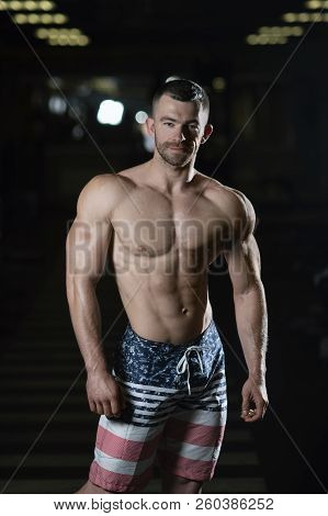 Strong Fitness Man Shows His Athletic Body In The Gym. The Concept Of A Healthy Lifestyle