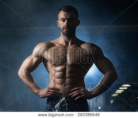 Strong Fitness Man Shows His Athletic Body In The Gym. The Concept Of A Healthy Lifestyle