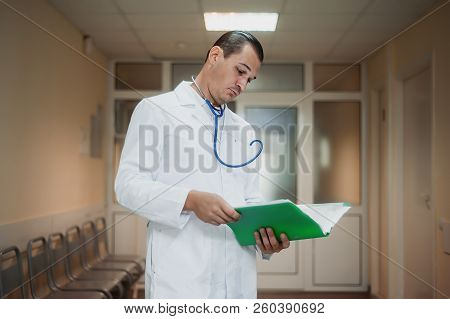 Young Doctor Looking At A Folder In The Hospital