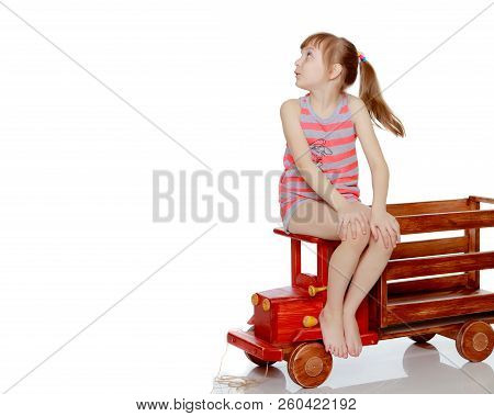 Beautiful Little Caucasian Girl With A Short Bangs And Hair Tucked Into A Tail. In Striped In A T-sh