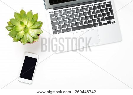 Conceptual Workspace Or Business Concept. Laptop Computer With Plant In A Pot And Modern Cell Phone 