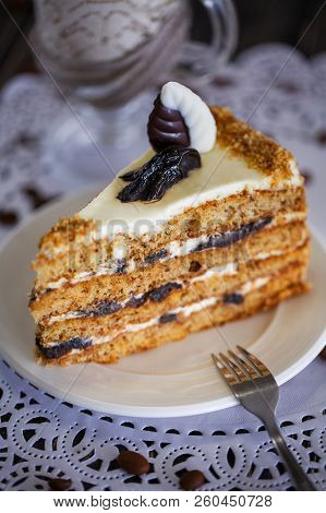 Cake With Honey And Prunes On White Plate