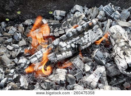 Beautiful Red Flame From Slice Wood, Dark Grey Black Coals Inside Metal Brazier. Wood Burning In The