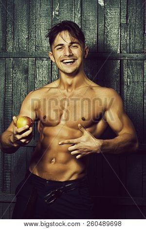 Sexy Smiling Emotional Muscular Young Man With Bare Torso Holding Healthy Foor Of Apple Fruit Standi