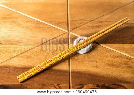 Natural Bamboo Chopsticks On Wooden Table Background.