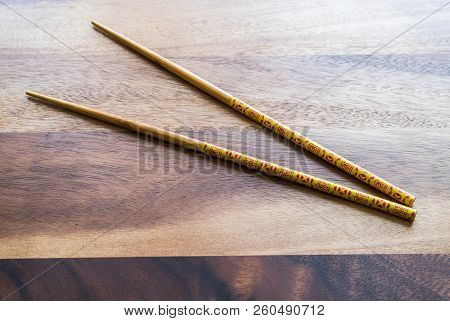 Natural Bamboo Chopsticks On Wooden Table Background.