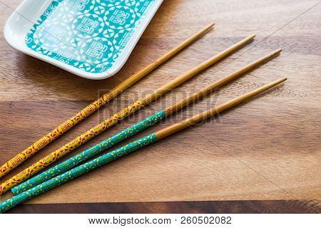 Natural Bamboo Chopsticks And Plate On Wooden Table Background.