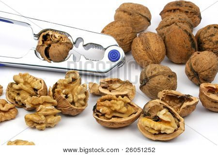 Nueces agrietadas y cascanueces sobre fondo blanco